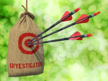 Investigation - Three Arrows Hit in Red Target on a Hanging Sack on Green Bokeh Background.
