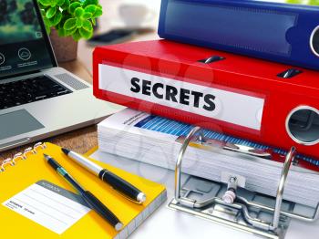 Secrets - Red Ring Binder on Office Desktop with Office Supplies and Modern Laptop. Business Concept on Blurred Background. Toned Illustration.