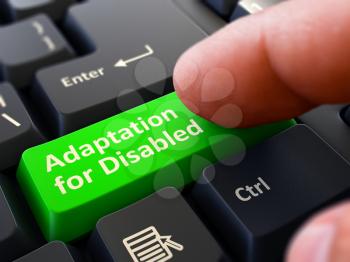 Adaptation for Disabled Button. Male Finger Clicks on Green Button on Black Keyboard. Closeup View. Blurred Background.