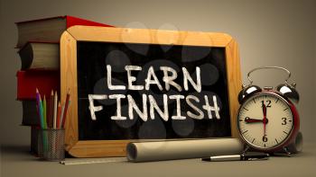 Hand Drawn Learn Finnish Concept  on Chalkboard. Blurred Background. Toned Image.