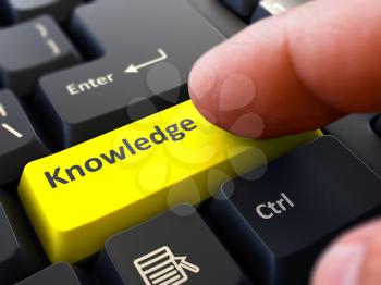 Knowledge - Written on Yellow Keyboard Key. Male Hand Presses Button on Black PC Keyboard. Closeup View. Blurred Background.