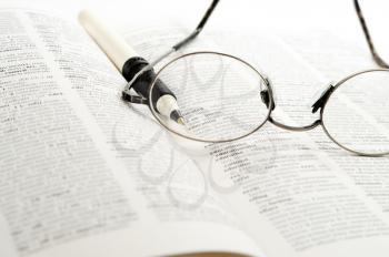 Royalty Free Photo of a Reading Glasses and a Pen on a Book