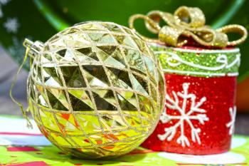 Macro shot of a golden christmas tree ball sorrounded by other decorations