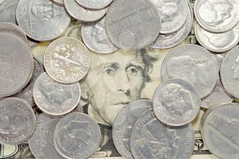 Bunch of coins on a twenty dollar bill