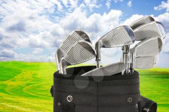 Golf bag with clubs against a beautiful fairway and a blue sky