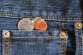 Macro shot of a jean's pocket with coins coming out of it