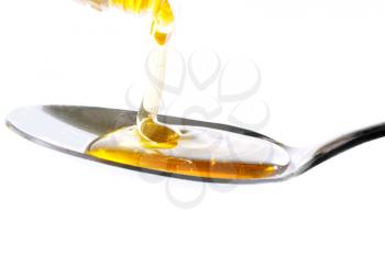 Honey falling on a spoon isolated on a white background