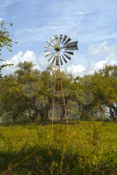  Old farm water pumping wind mill in a pasture field
