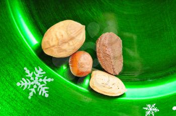 Macro shot of a few nuts on a green christmas plate