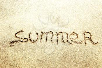 the word summer written on the sand at a tropical beach