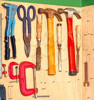Several tools hanged on a plywood sheet inside a wokshop
