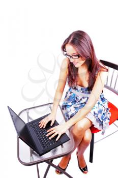 Very attractive young woman working on a laptop isolated on white