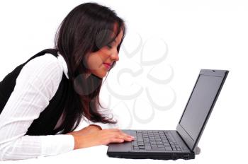 Young girl laying down and working on a laptop 