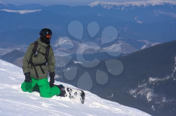 The snowboarder-freerider is sitting on the brink of a precipice.