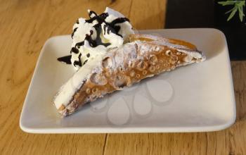 Sicilian Style Cannoli on white plate with cream