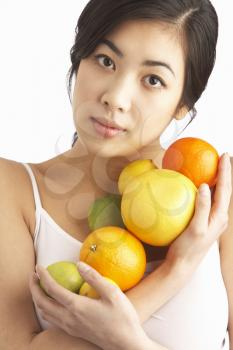 Young Woman Holding Citrus Fruit In Studio