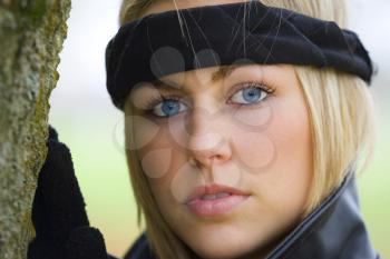 A beautiful blue eyed young woman wearing a black headband.
