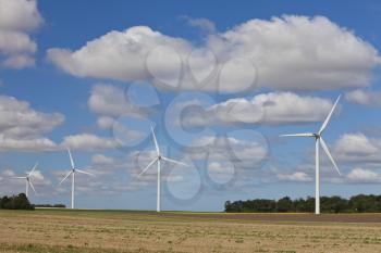A farm of four wind turbines or windmills providing alternative sustainable green energy.
