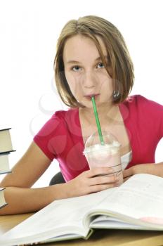 Teenage school girl studying with a milkshake