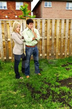 Young couple worried about growing lawn in backyard of new home