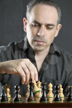 Man moving a chess pawn on wooden chessboard as first move