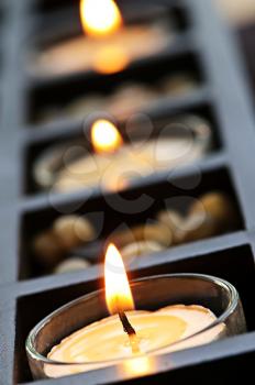 Burning candles in glass holders and wooden stand