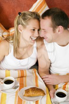 Couple having breakfast in bed in the morning
