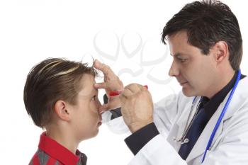 A doctor shines a light into child's eye to check vision ocular health  and responsiveness.