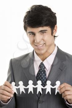 Photo of handsome man holding symbolic paper people in hands