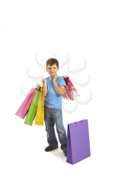 Image of smiling boy holding bags with presents or shoppings looking at camera