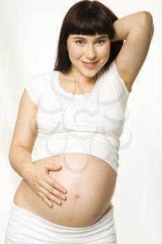 Portrait of pretty pregnant woman wearing white tanktop and looking at camera with smile