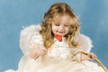 Photo of adorable female cupid holding bow