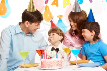 Portrait of happy boy having his birthday party with parents and elder brother near by