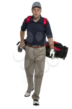 Male golfer walking along carrying his bag.