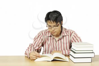An isolated shot of a young man reading books