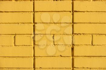 Yellow old painted grungy brick wall texture