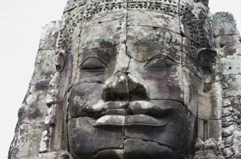 Ancient stone face in Bayon Temple, Angkor Wat complex, Siem Reap, Cambodia. UNESCO World Heritage Site.
