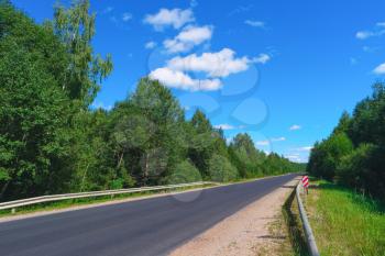 Empty highway with green forest on both sides