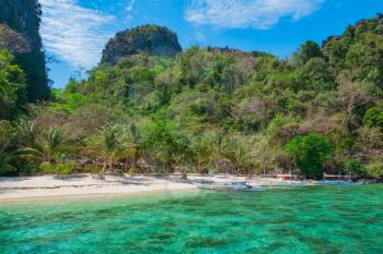 Scenic view of beautiful tropical white sand beach and rock island, El Nido, Palawan, Philippines