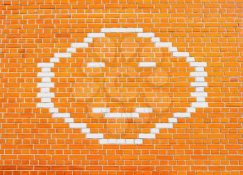 Happy Smiley Face on bright orange brick wall