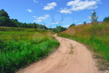 Beautiful summer landscape with road, sky, clouds, grass and trees