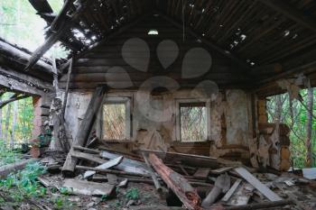 Ruins of old abandoned wooden house. Destroyed room with windows.