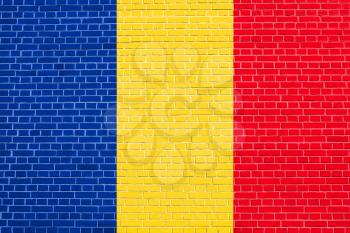 Flag of Romania on brick wall texture background. Romanian national flag.