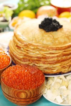  lot of red caviar in wooden plates with pancakes
