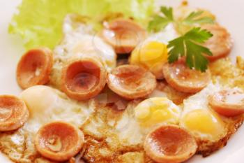 fried quail eggs with sausage and greens
