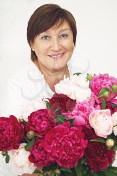  elderly woman holding a bouquet of peonies