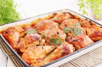 Baked chicken drumsticks on a baking tray 