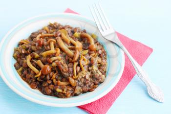 Lentil stew with wild mushrooms on a blue