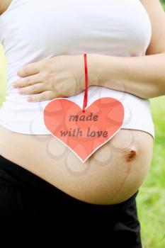 Pregnant woman with a nameplate in the shape of heart