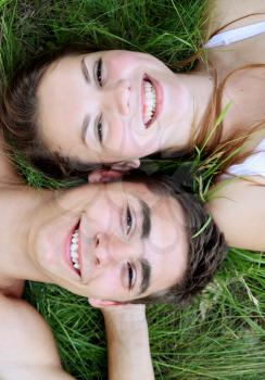Young couple lying on the grass, top view